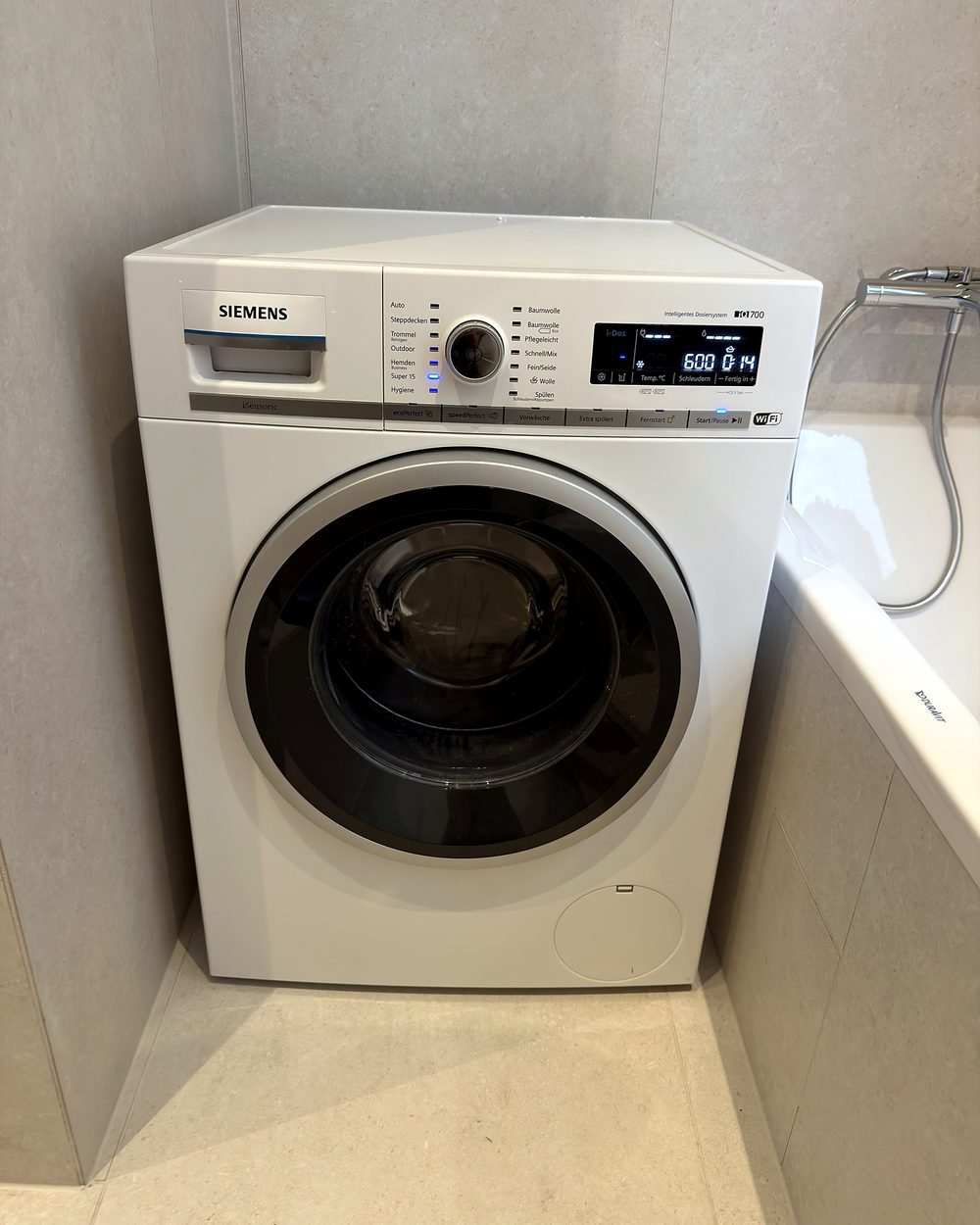 Frontlader-Waschmaschine in einem Badezimmer, angeschlossen